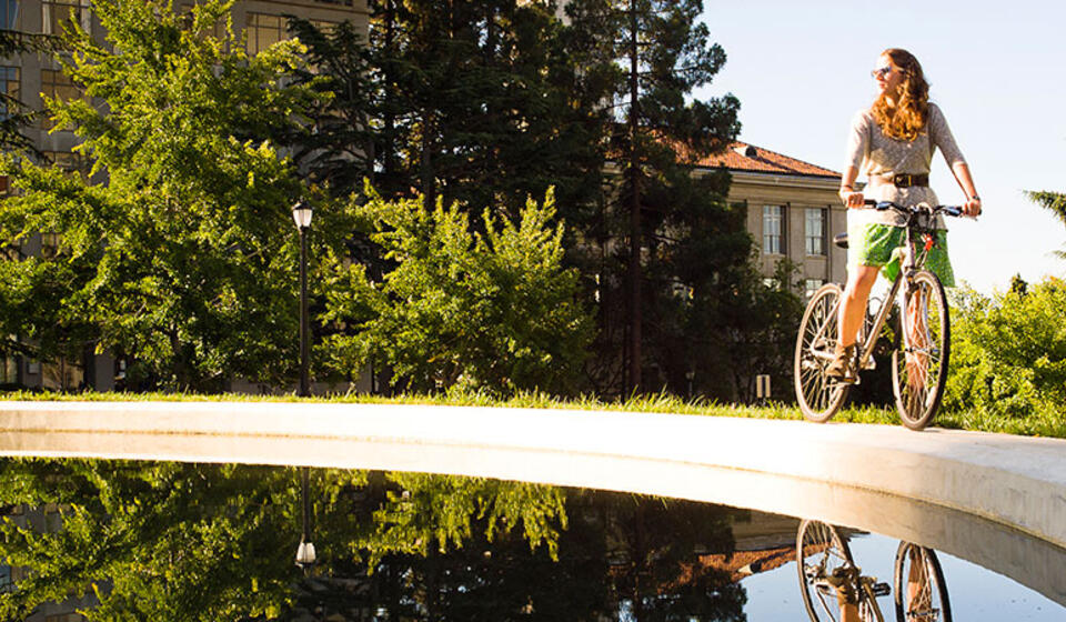 Student on bike next to fountain